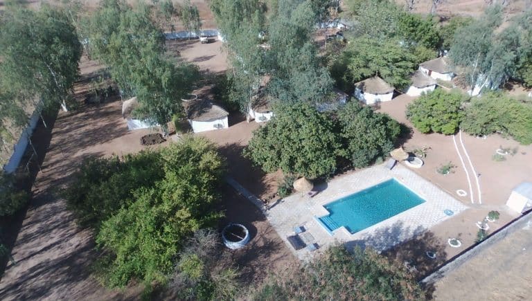 Les lodges au toit de chaume et la piscine, vus du ciel