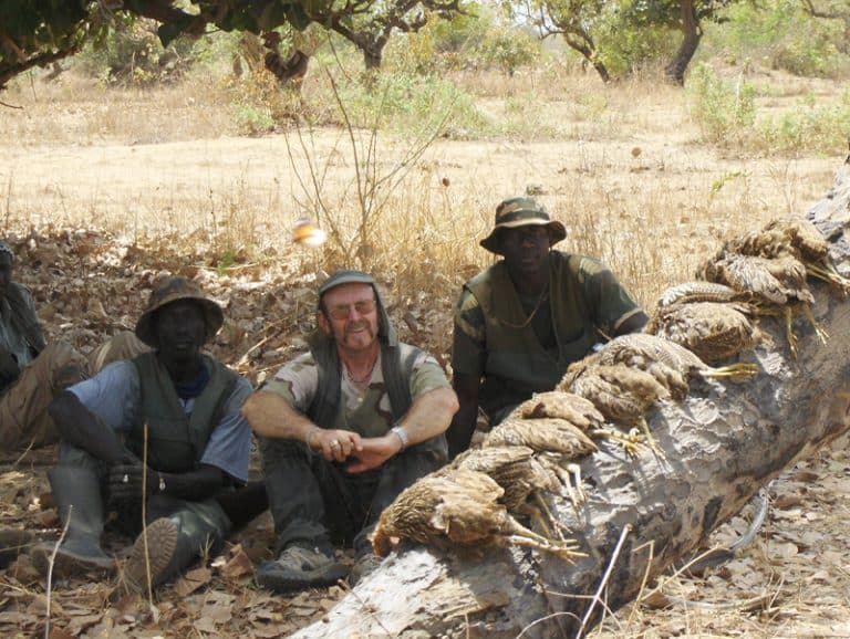 Chasseur et pisteurs à la pause, le tableau de francolins posé sur un tronc