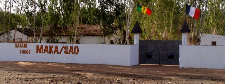 Le portail du Safari Lodge Maka/Sao sous les drapeaux sénégalais et français