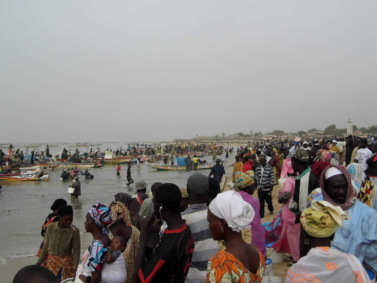 Foule sur la plage au retour des pirogues de pêche